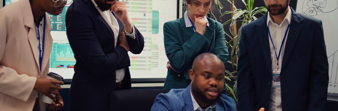 Diverse corporate employees analyzing project updates to ensure goal accomplishment, reviewing infographics on laptop and finding ways to obtain new funds. Business management team. Camera B.
